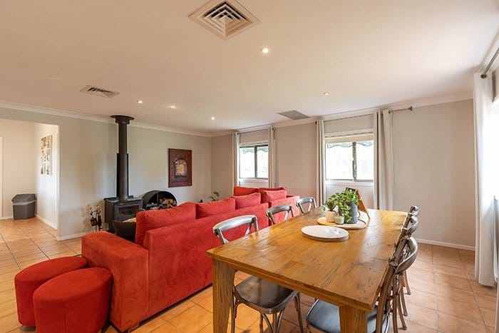 Living and dining area at Hunter Gleann with a wood fire and red sofas