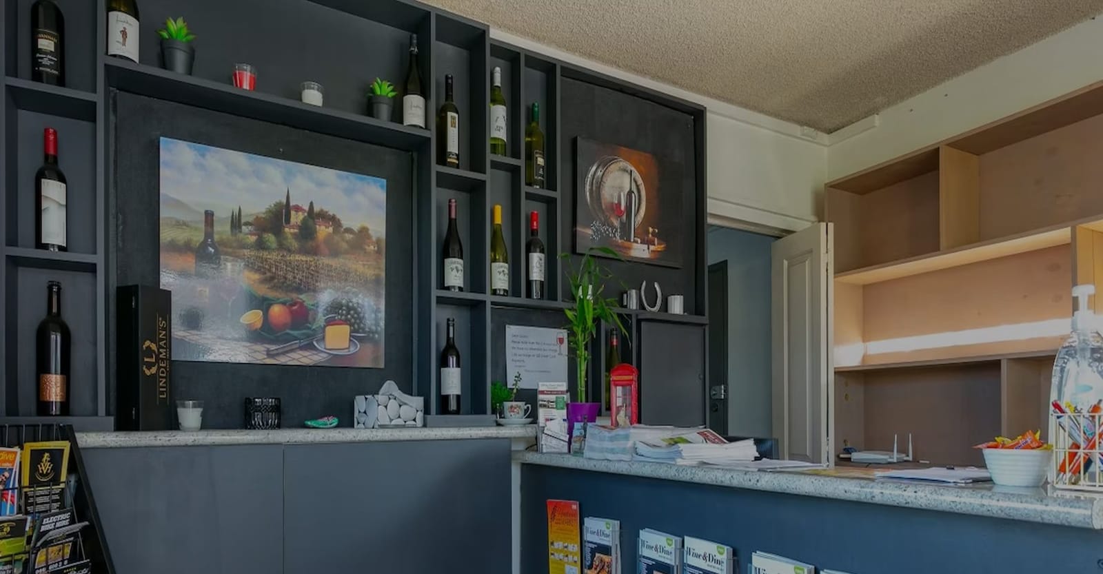 Wine-themed reception area with bottle display at Hunter Valley Motel, Cessnock, Hunter Valley