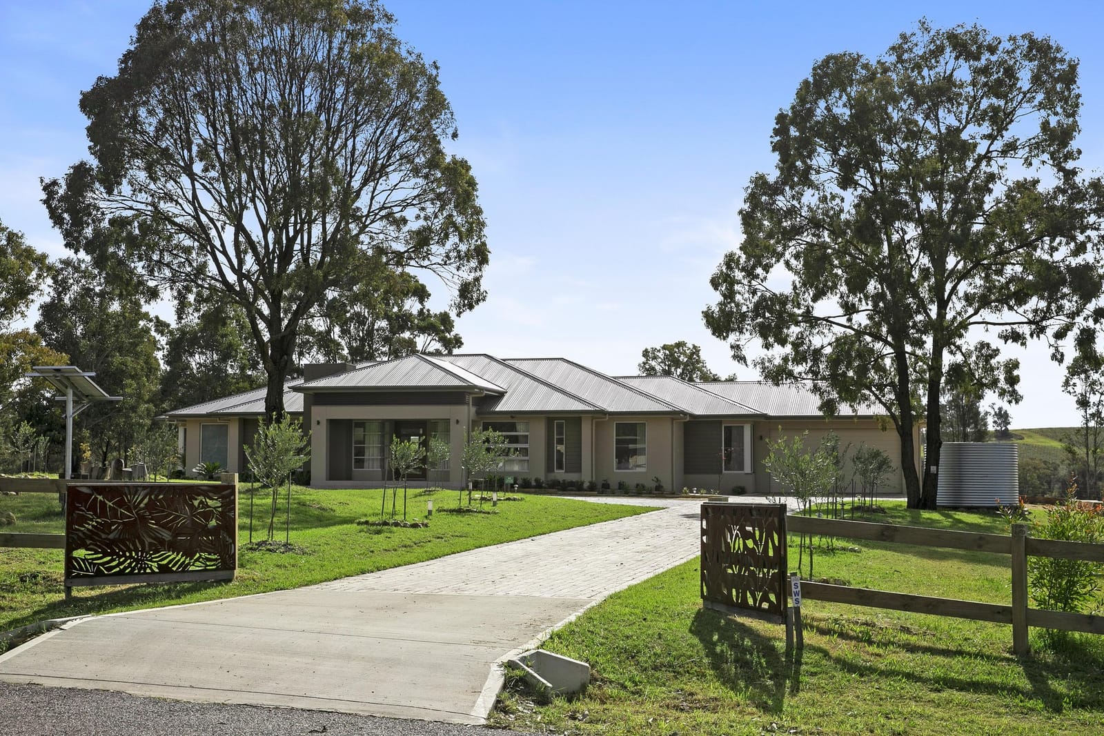 Front exterior and driveway of Kalamata Retreat, a single-storey brick house on acreage at Pokolbin.