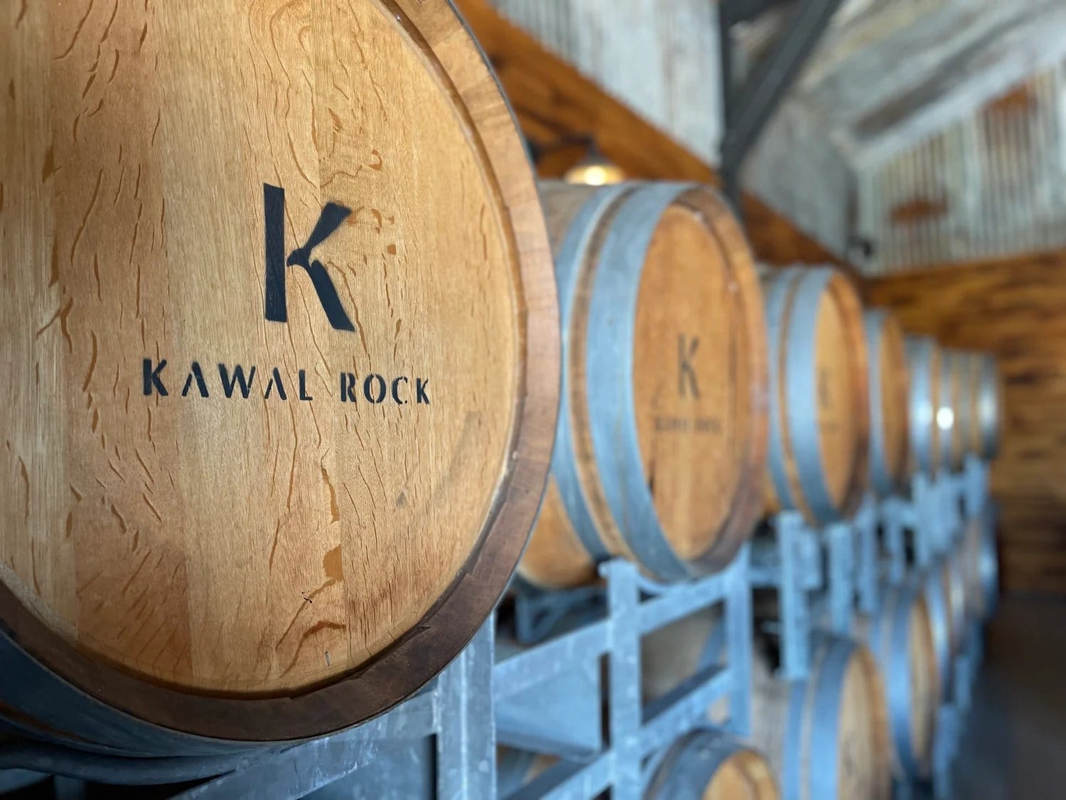 Oak barrels stamped with the Kawal Rock mark, stacked in the distillery's barrel store
