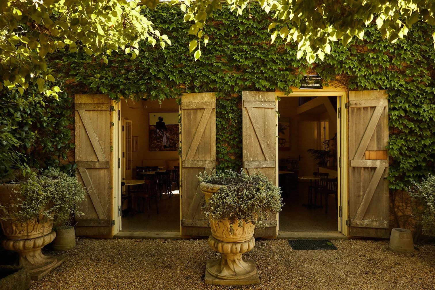 Ivy-covered cellar door entrance with wooden barn doors at Krinklewood, Broke, Hunter Valley