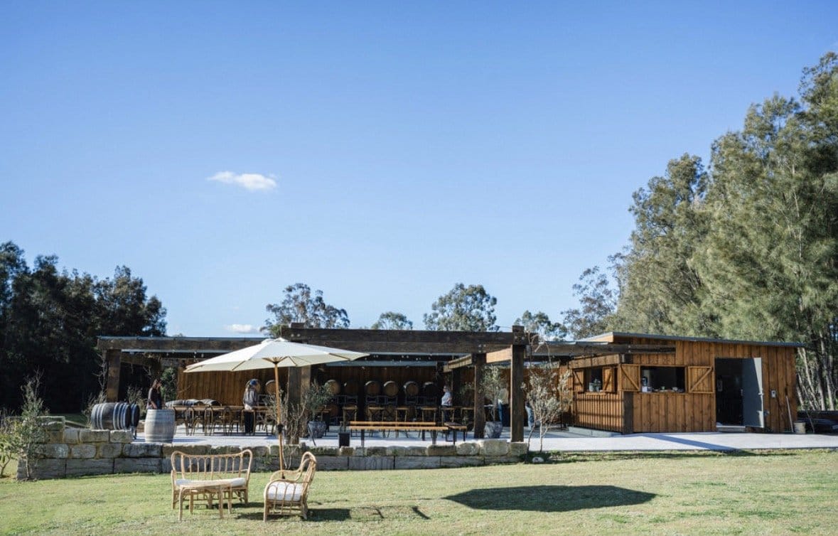 Exterior view of La Vigna Estate's stone building and covered outdoor terrace at Pokolbin