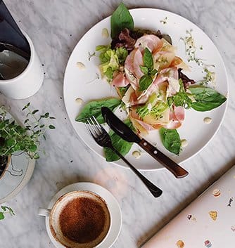 Plated dish with prosciutto and salad greens served at La Vigna Estate's restaurant