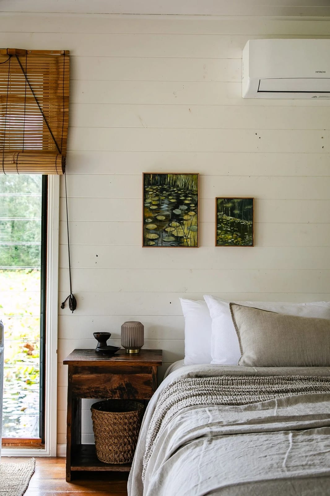 A boathouse bedroom with linen bedding and a window over the water