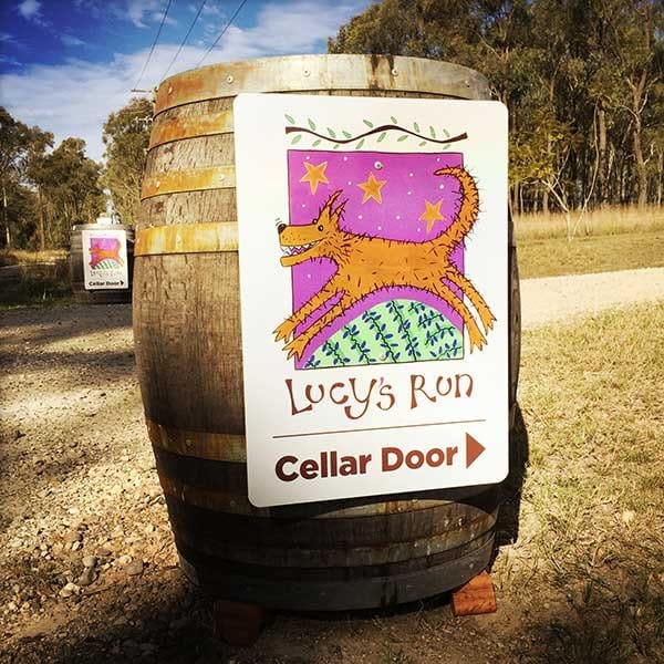 Wine barrel with Lucy's Run logo in rural setting