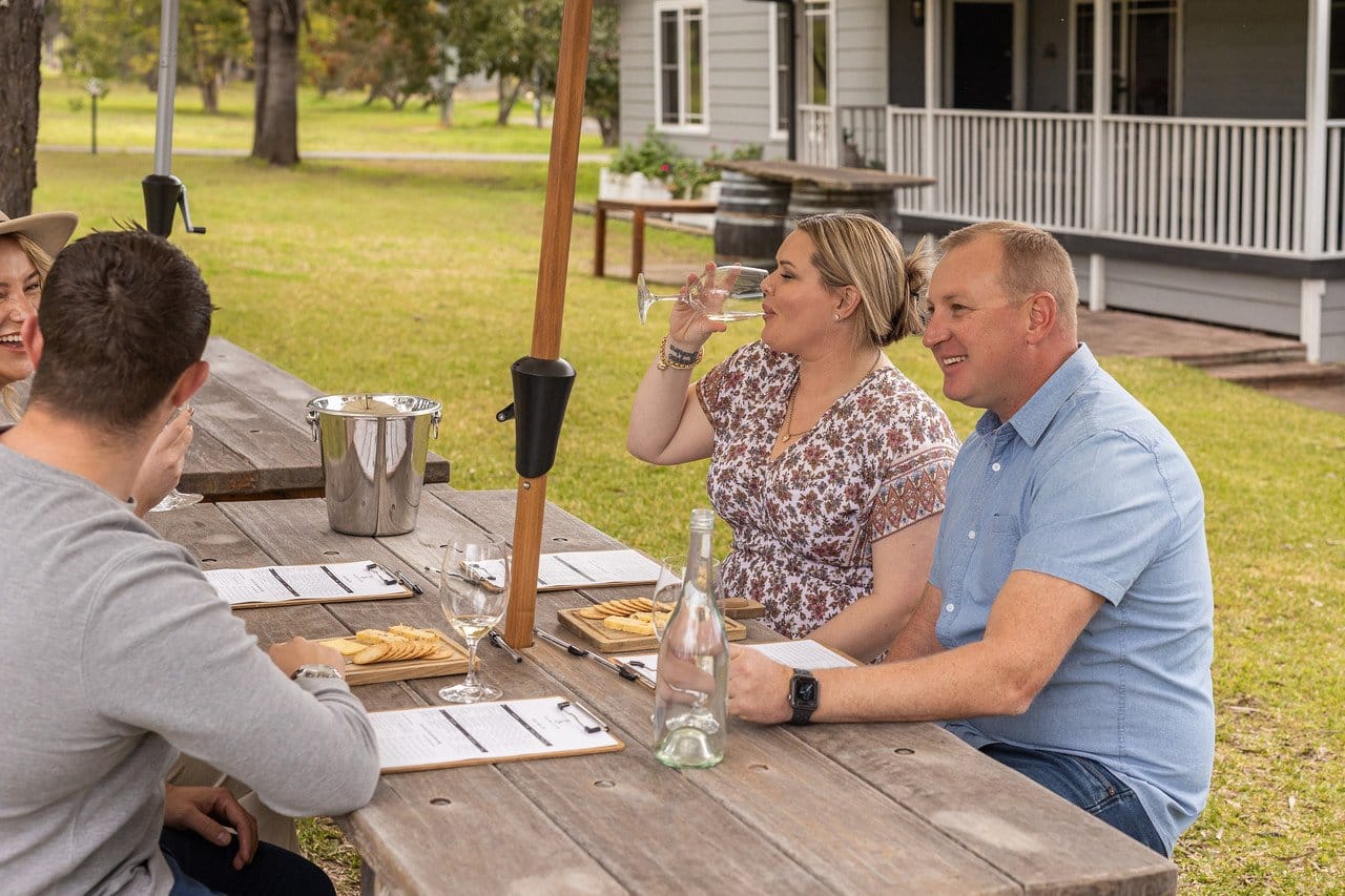 Visitors tasting wine at outdoor table at McCaffrey's Estate, Pokolbin, Hunter Valley