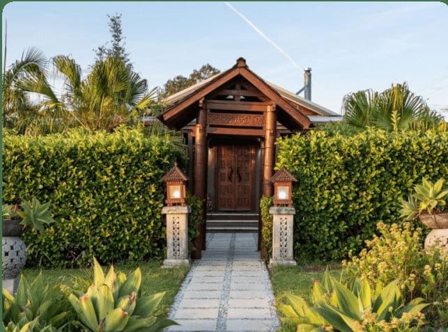 Villa entrance with timber cladding and tropical plantings