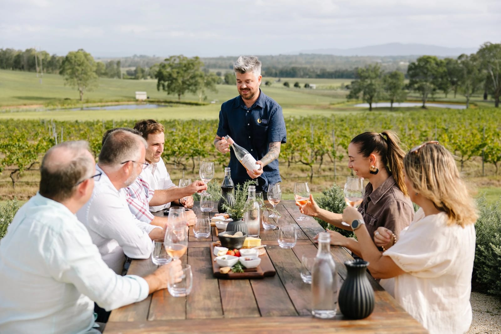 Hosted tasting at outdoor table with vineyard beyond at Molly Morgan, Lovedale, Hunter Valley