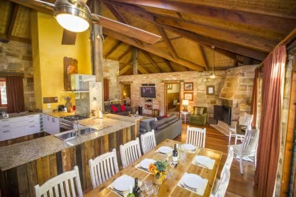 The open-plan kitchen, dining and living area under the raked timber ceiling