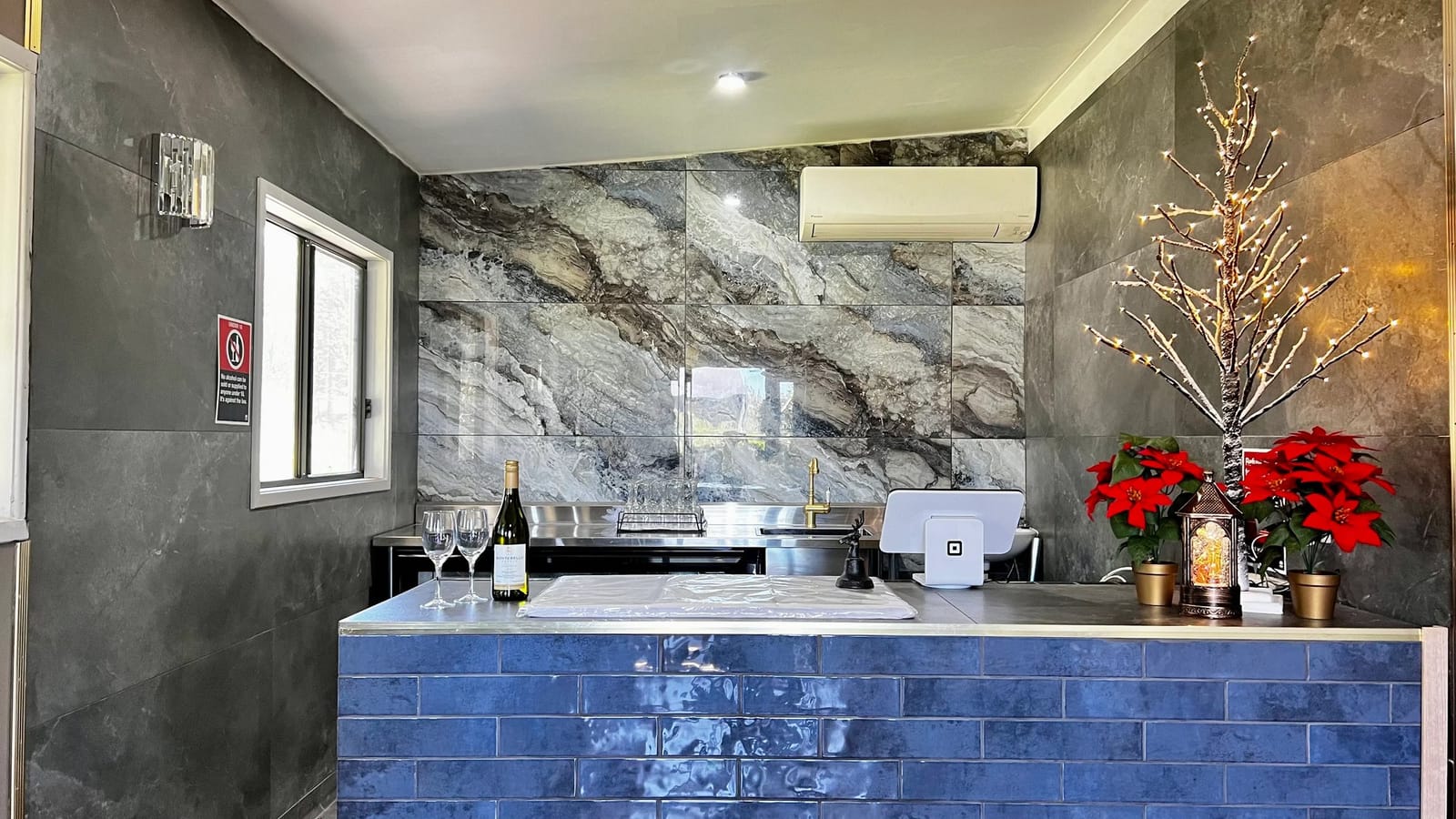 Modern tasting room with marble walls, blue counter and wine service setup