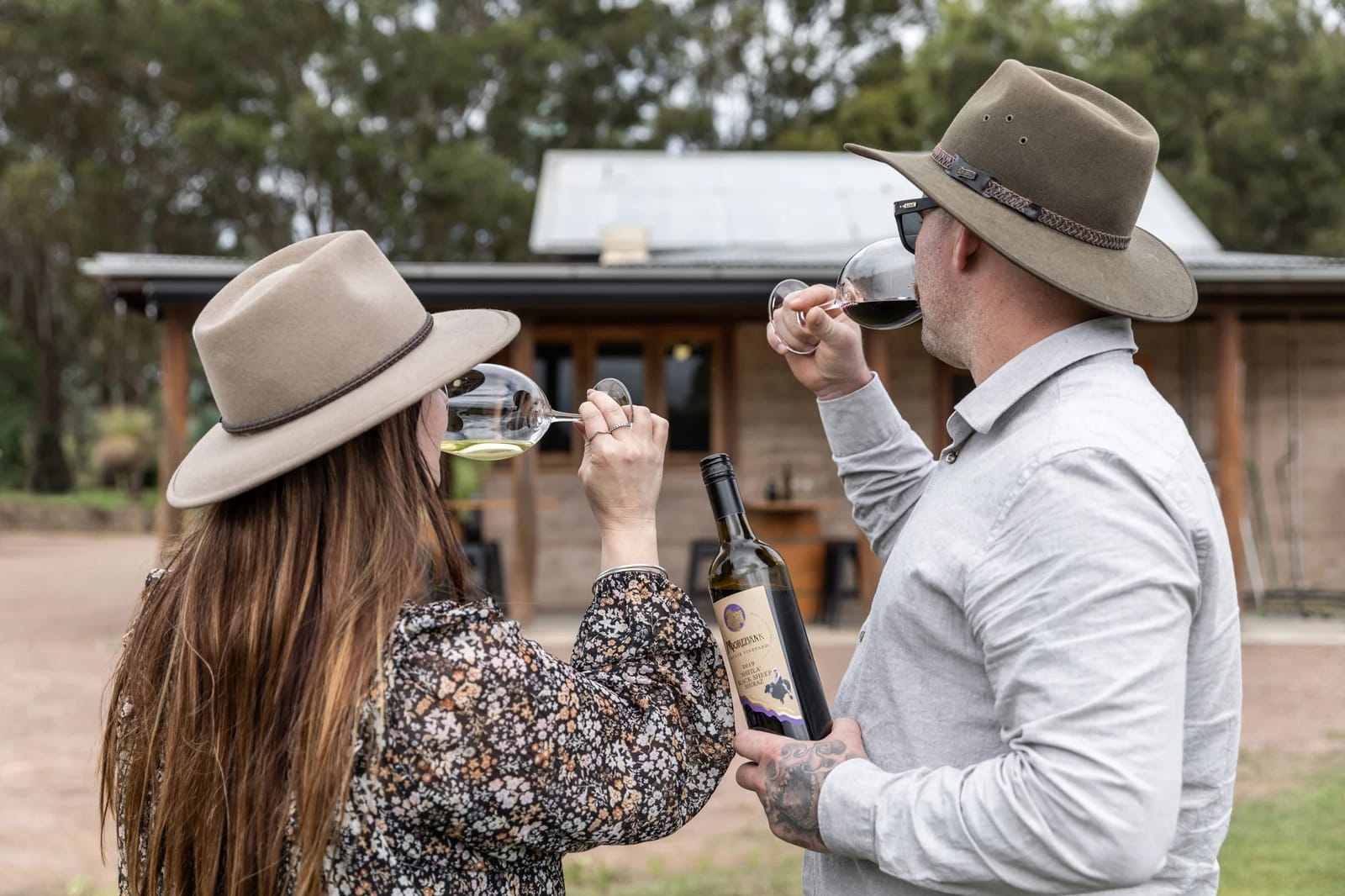 Couple tasting wine outdoors near vineyard at Moorebank, Pokolbin, Hunter Valley