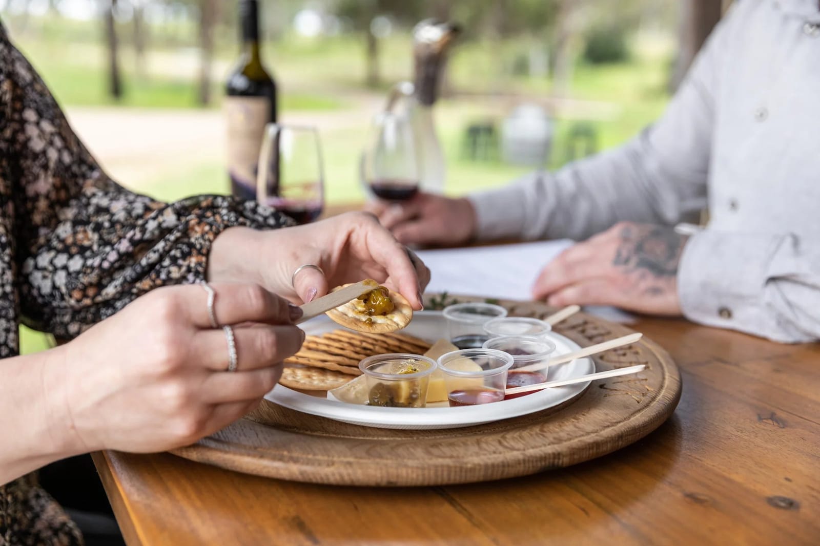 Outdoor wine tasting with cheese and crackers on wooden board