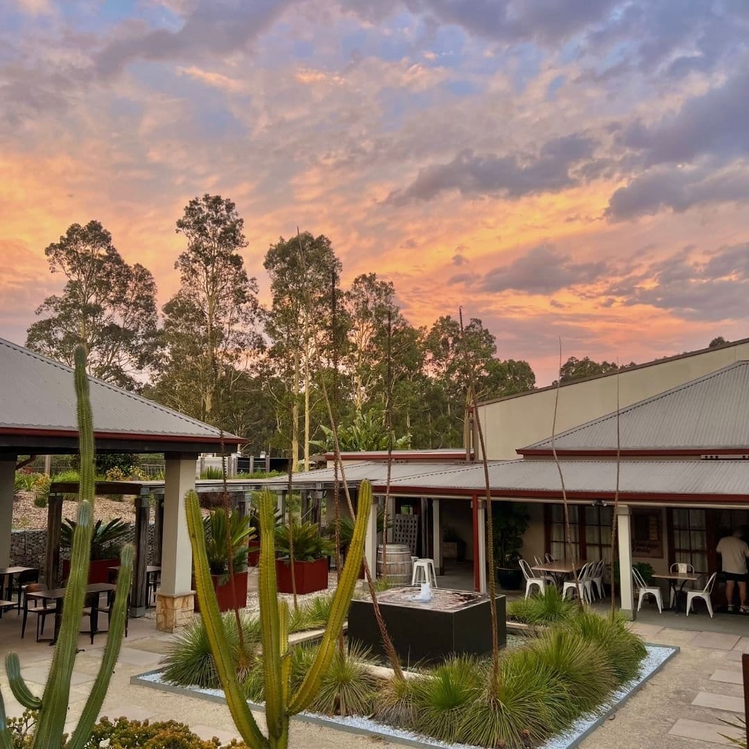 Outdoor courtyard and dining terrace at Ned's Cafe and Bar, Piggs Peake, at dusk.