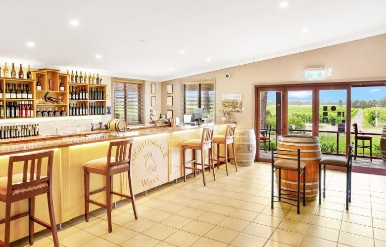 Modern cellar door with timber counter overlooking vineyards at Nightingale, Broke, Hunter Valley