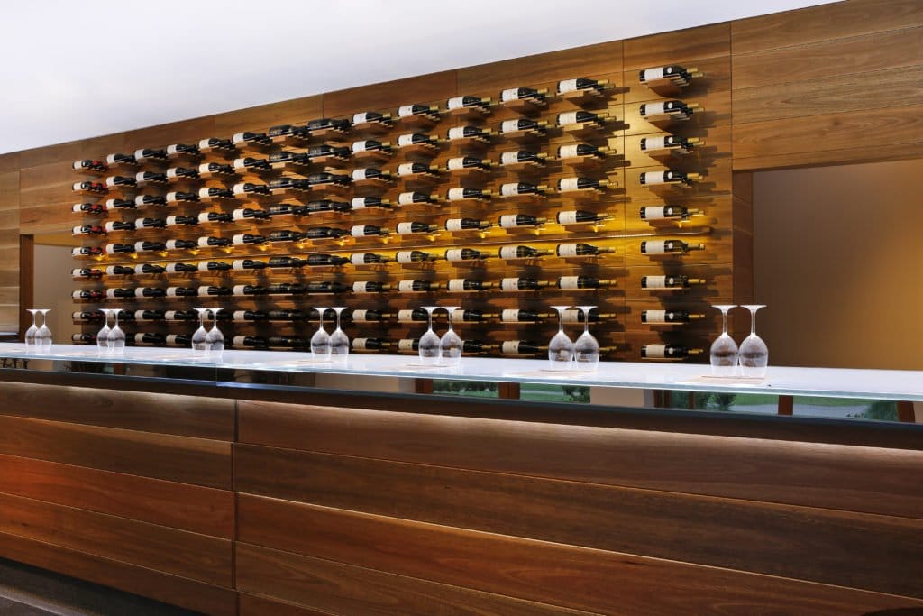 The long white tasting counter at Oakvale with the timber bottle wall behind it