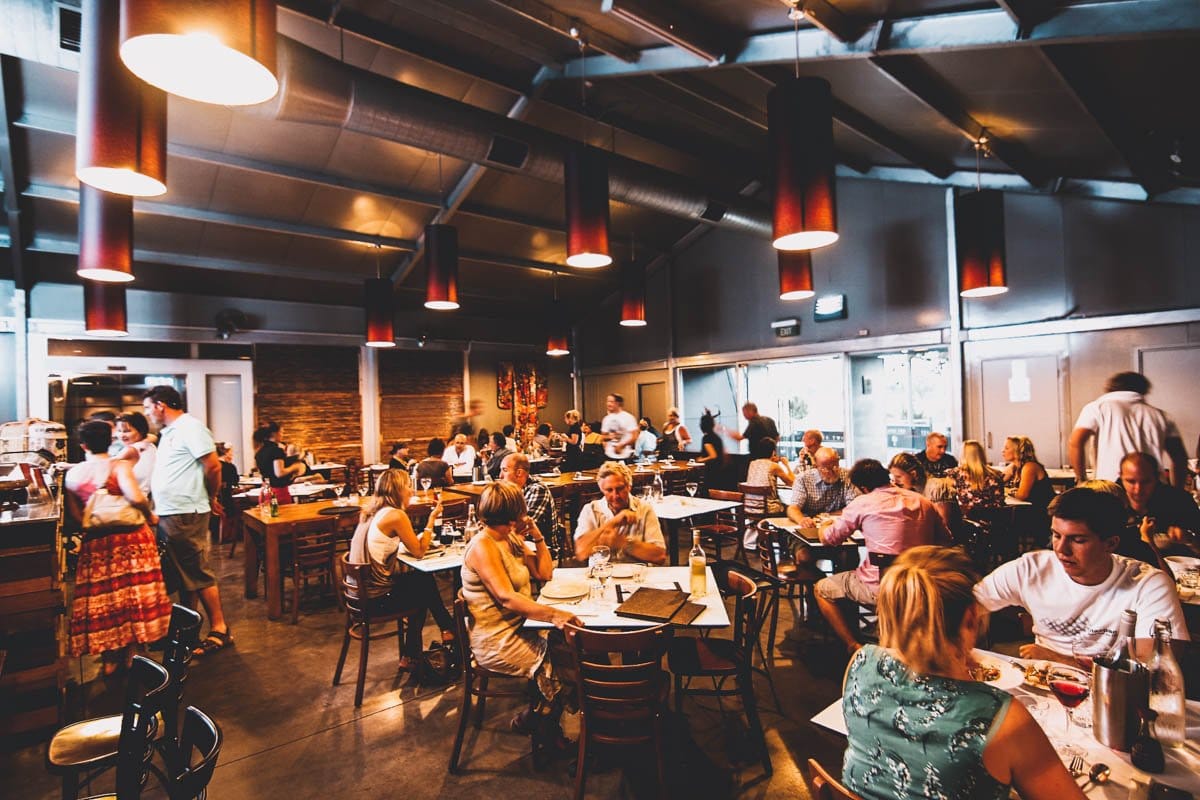 Busy dining room with diners at multiple tables indoors