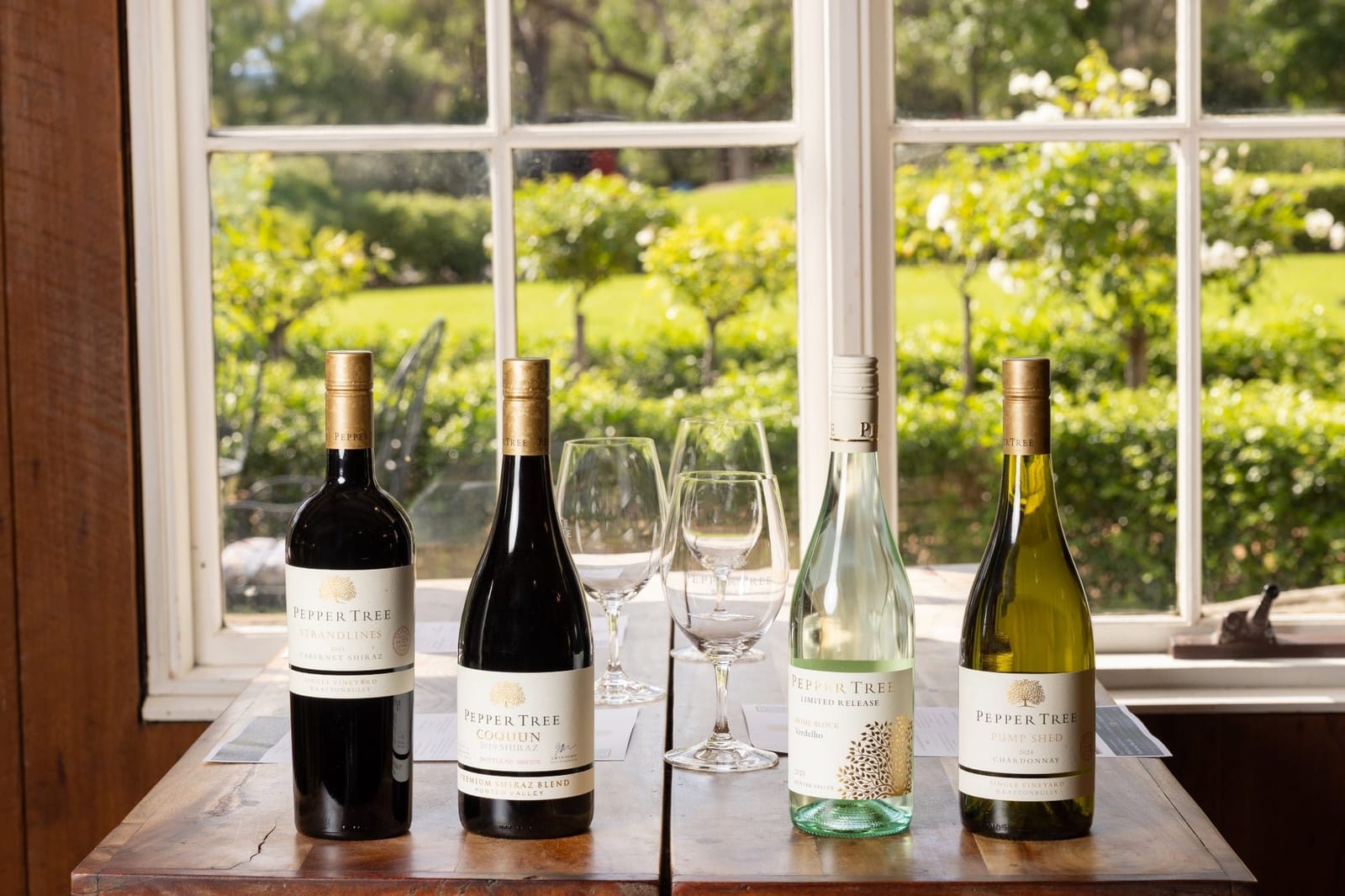Range of Pepper Tree wines and glasses on a table by the window