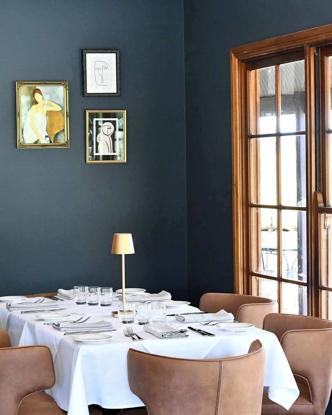 The dining room at Pescara, with gallery-hung art and leather chairs