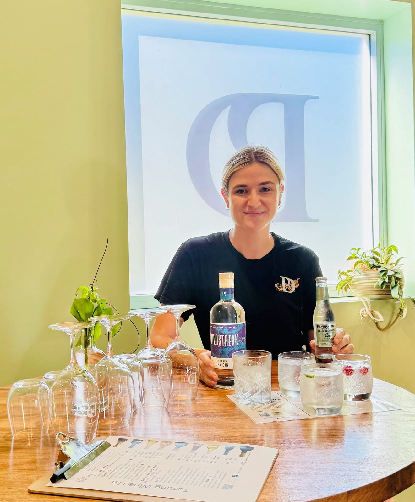 Woman pouring and tasting craft spirits at counter