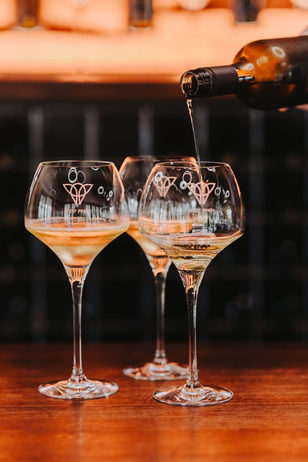 Wine being poured into branded glass during tasting
