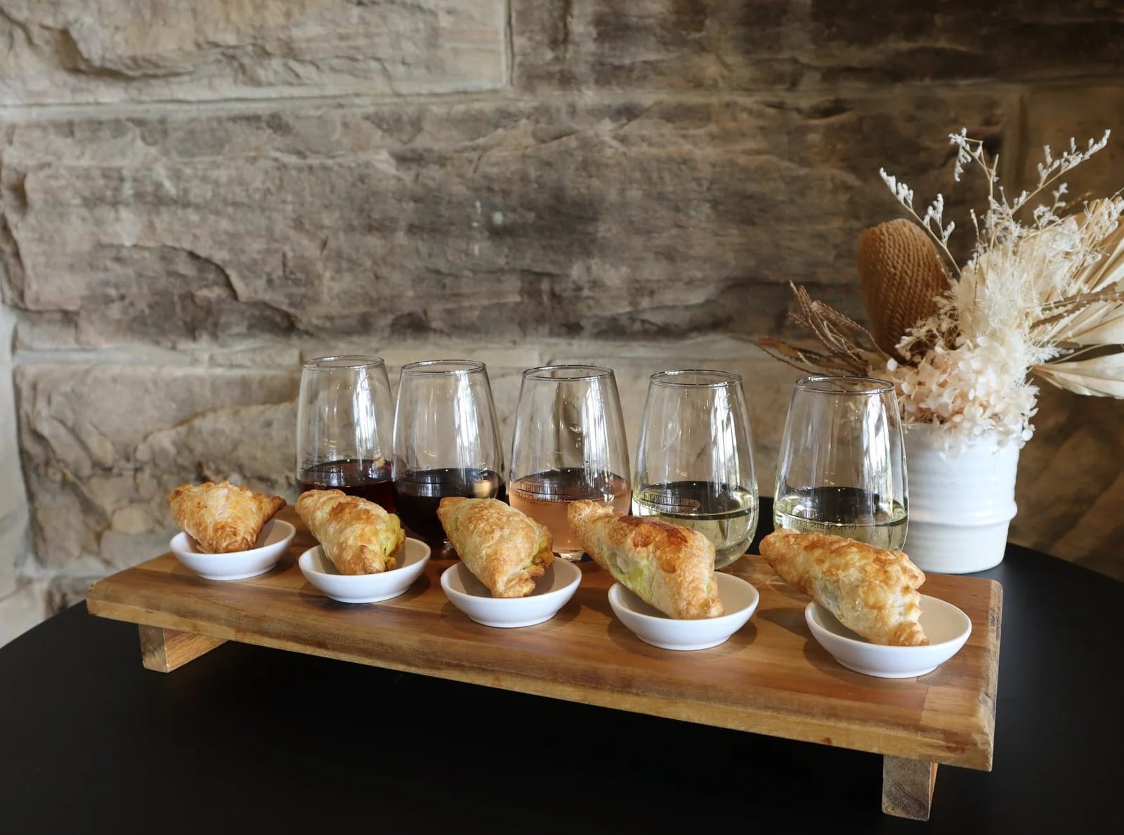 Wine flight with pastries on wooden board