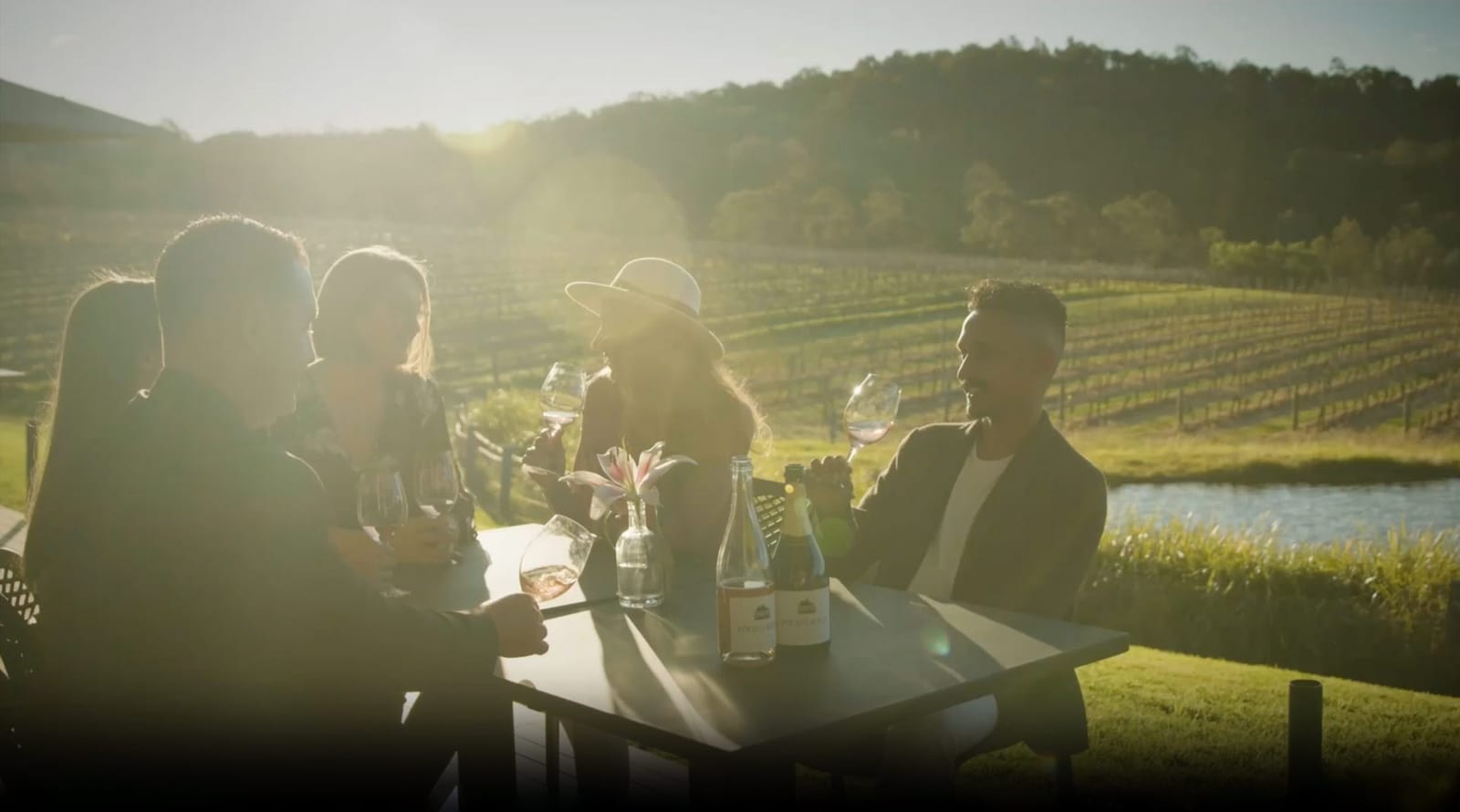 Group at table overlooking vineyard and water landscape at Pooles Rock, Pokolbin, Hunter Valley