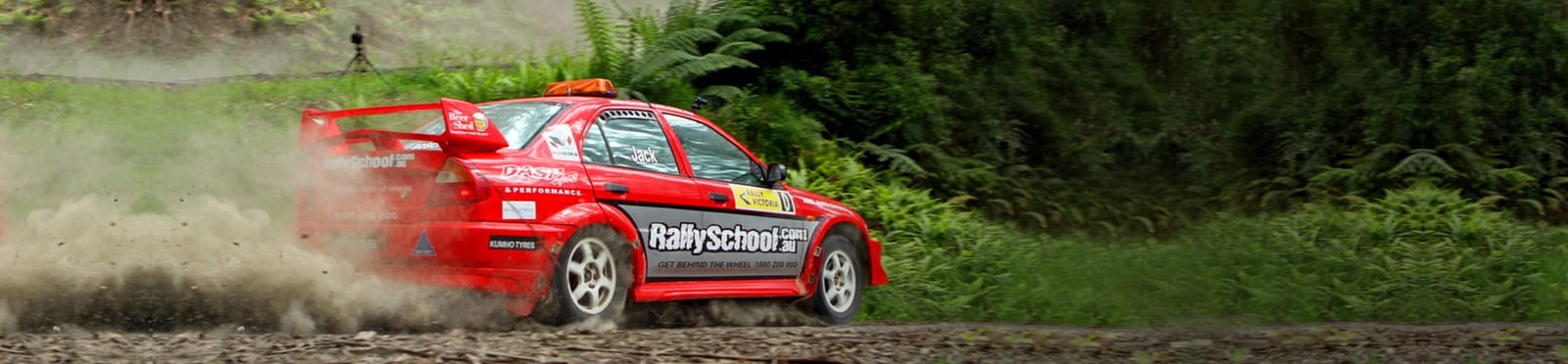 Red rally performance car sliding on gravel track at Rally School, Cessnock, Hunter Valley