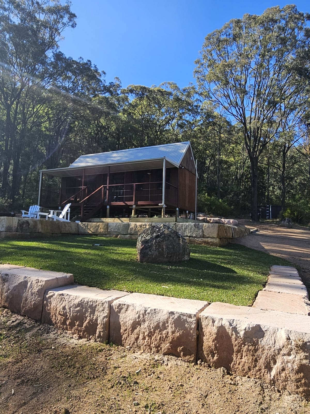 Timber cabin on a raised deck surrounded by bushland at Rocklee Grove, Broke