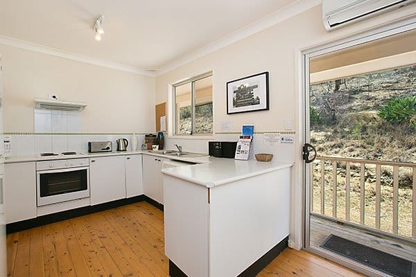 Kitchen interior with white cabinetry and patio access