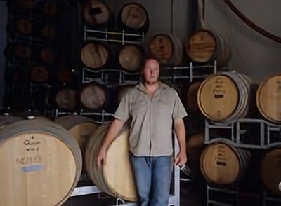 Winemaker standing among barrels at Running Horse, Broke Fordwich, Hunter Valley
