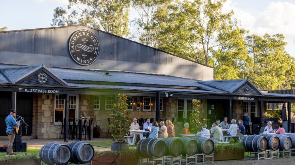 Winery exterior with wine barrels and outdoor seating at Saddler's Creek, Pokolbin, Hunter Valley