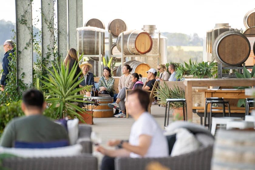 People in tasting lounge with barrels and vineyard view at Saltire, Lovedale, Hunter Valley