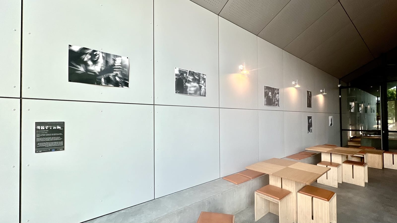 The cafe wall hung with a black and white photography exhibition above timber stools and tables