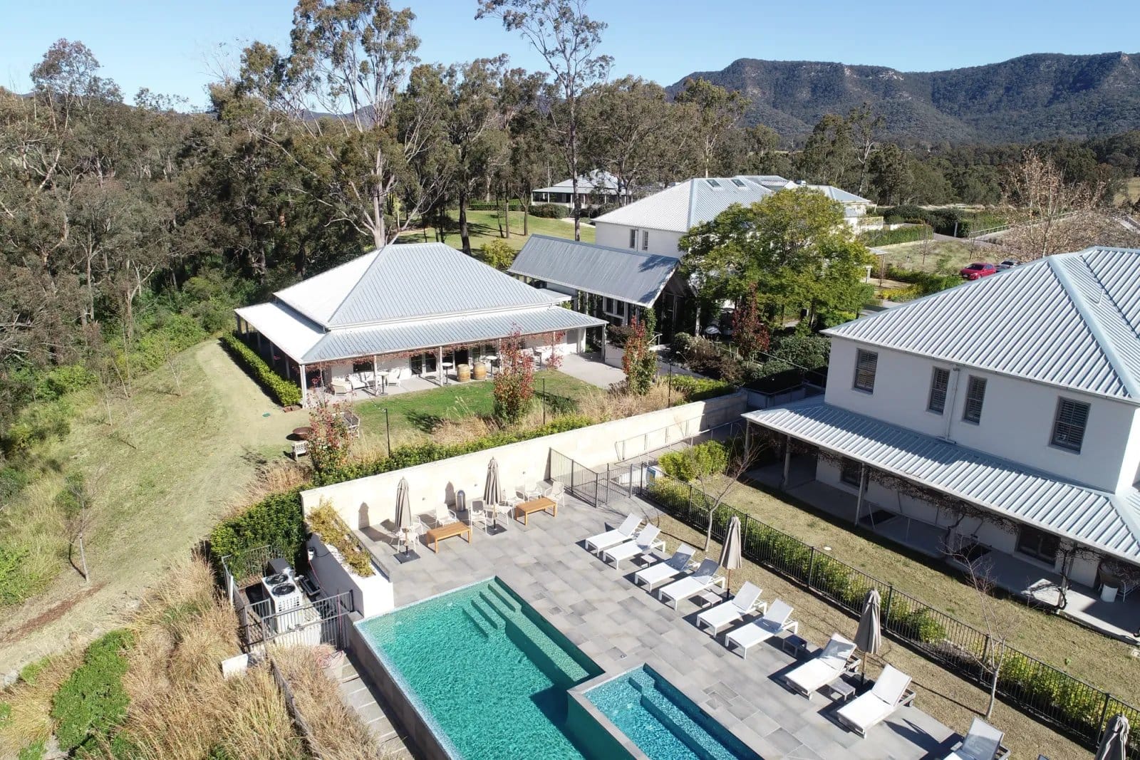 Aerial view of pool terrace, guest wings and Brokenback Range at Spicers Guesthouse, Pokolbin, Hunter Valley