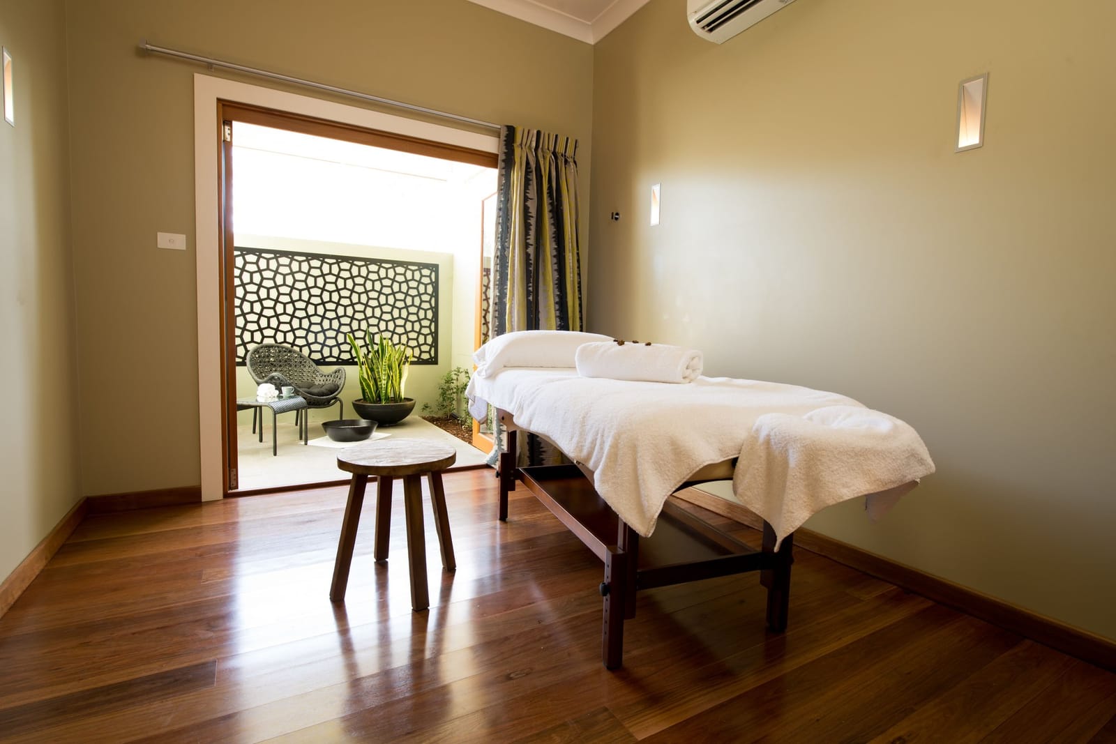 Spa room with massage bed and tropical plant decor