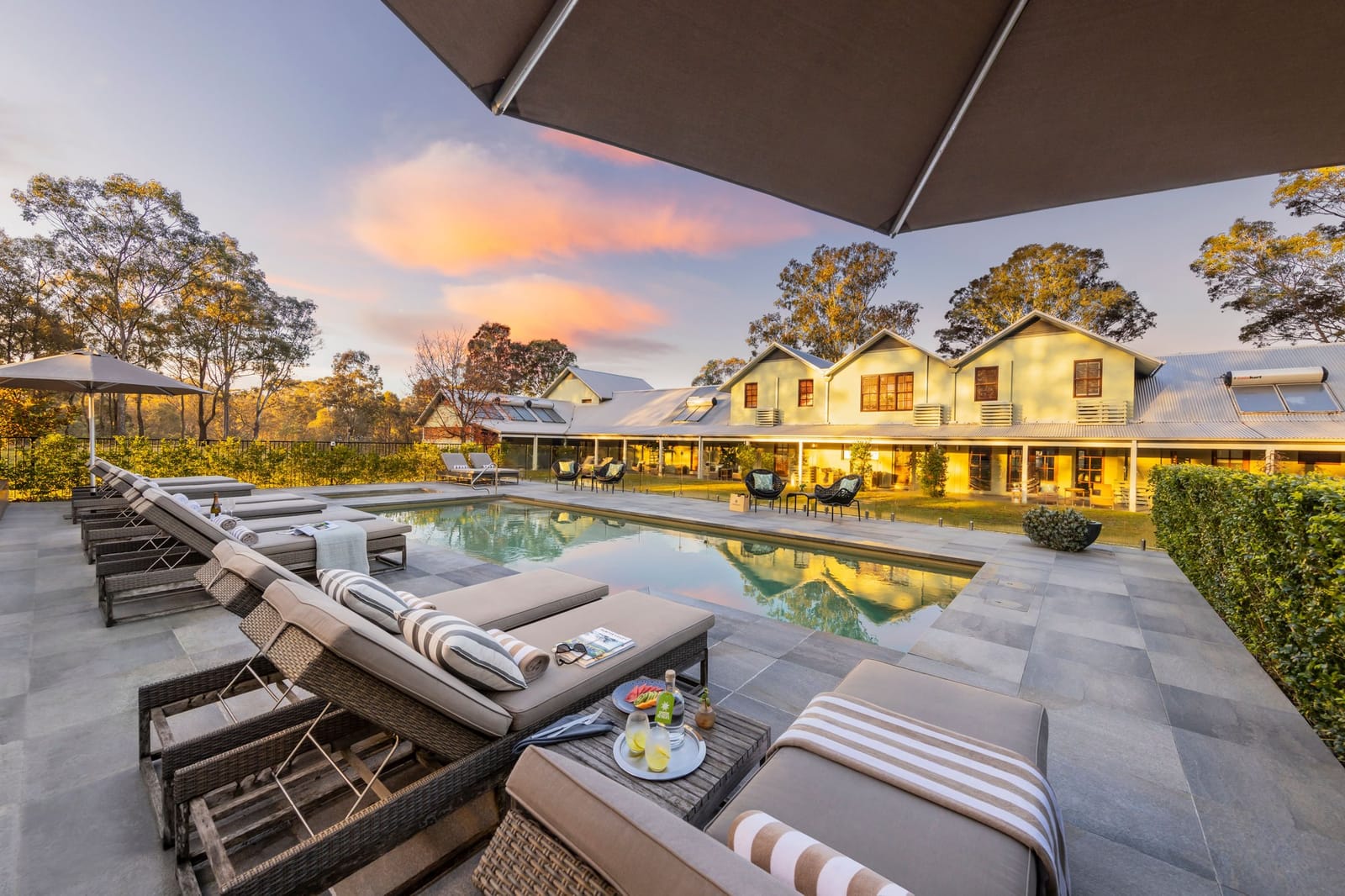 Resort pool area with manor house at dusk at Spicers Vineyards Estate, Pokolbin, Hunter Valley