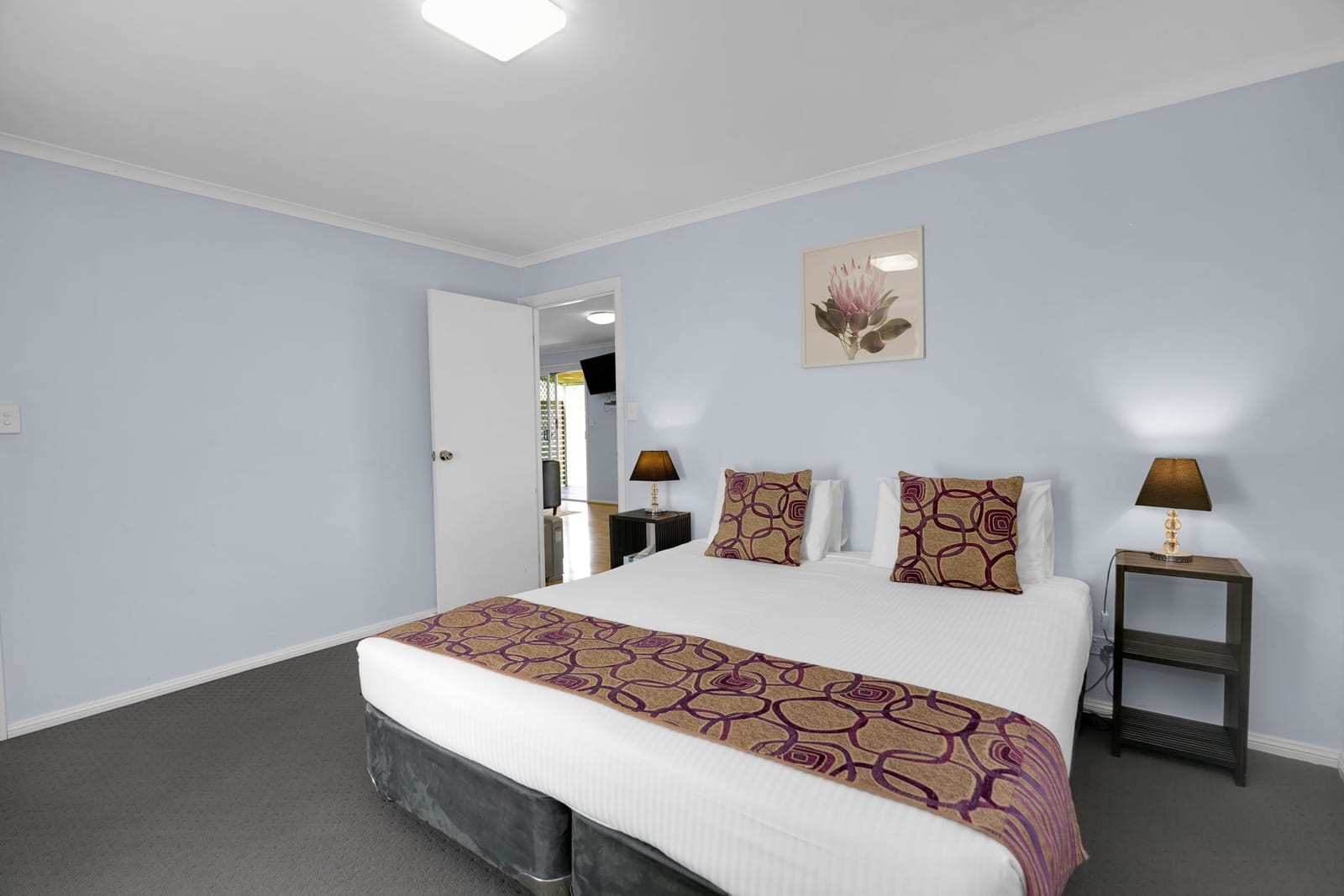 A cottage bedroom with a king bed and bedside lamps