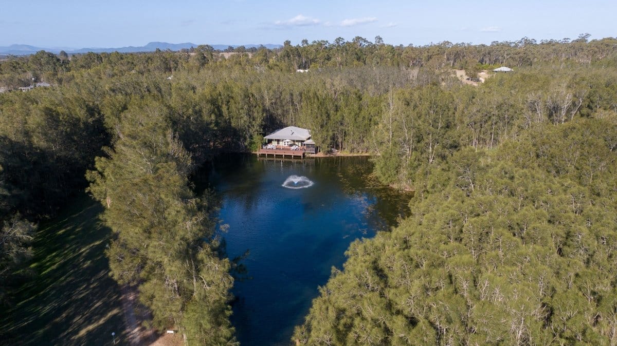 Aerial view of homestead beside private billabong fringed by casuarina trees at Sweetacres, Pokolbin, Hunter Valley