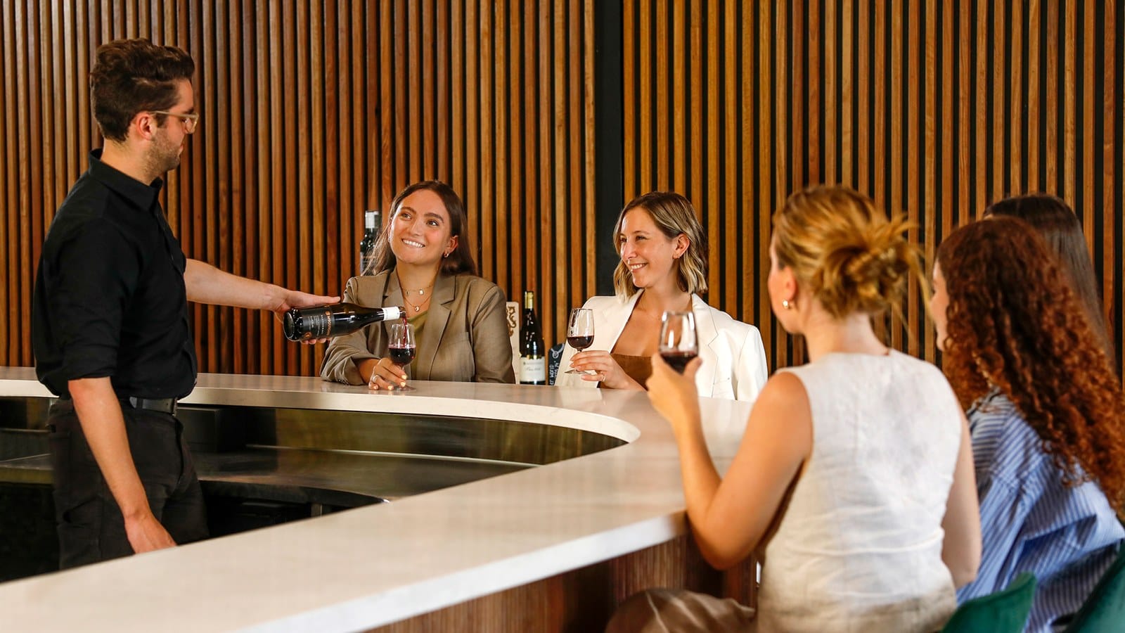 Guests being served at the curved Tempus Two tasting bar
