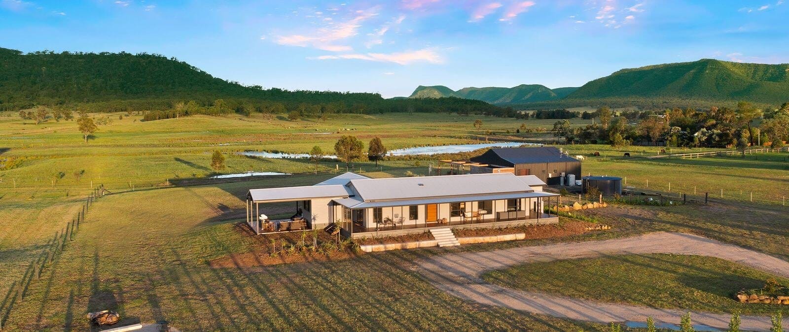 Modern pavilion building in valley with forested mountains at The Charles at Broke, Hunter Valley