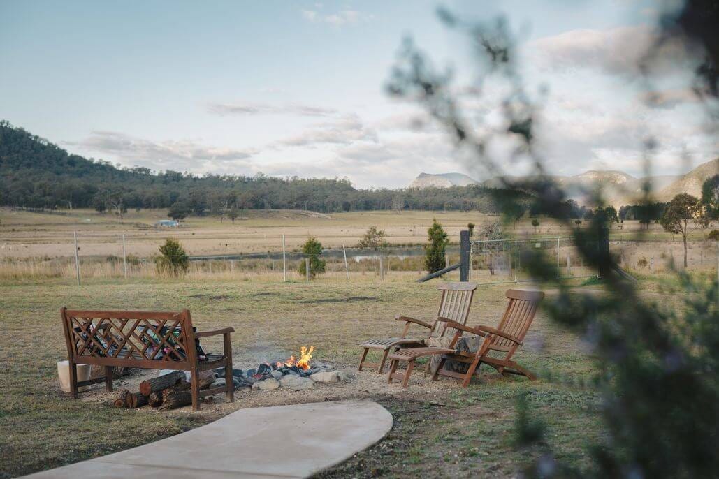 Fire pit seating area with chairs overlooking countryside