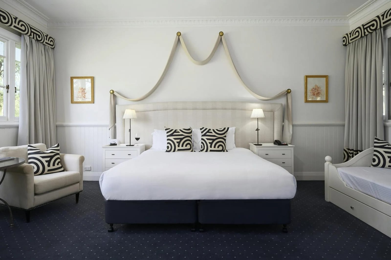 A Deluxe Room with a king bed and draped canopy