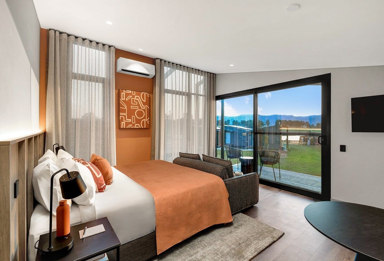 Studio room interior with king bed and floor-to-ceiling window overlooking the vineyard at The Lane Retreat