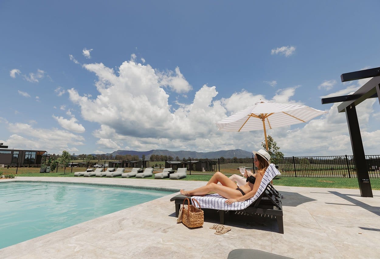 Swimming pool and sun loungers at The Lane Retreat, with vineyard and hills in the background
