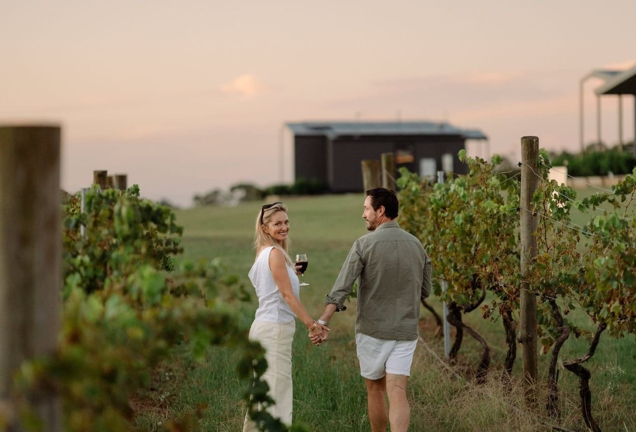 Couple enjoying wine in vineyard at sunset at The Lane Retreat, Pokolbin, Hunter Valley