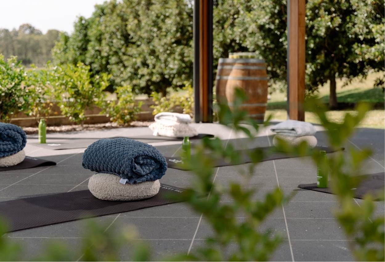 Yoga mats set out on an outdoor deck at The Lane Retreat, with vineyard views