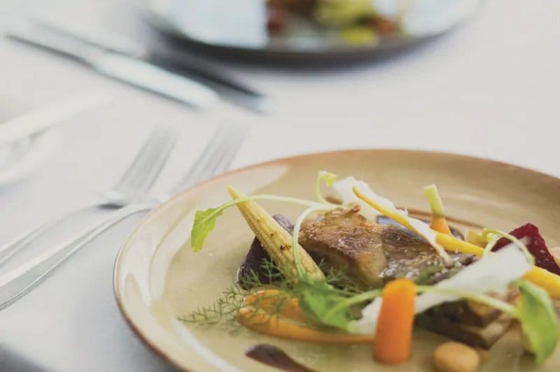 Plated seasonal dish with roasted vegetables and herbs at The Mill Restaurant, Pokolbin