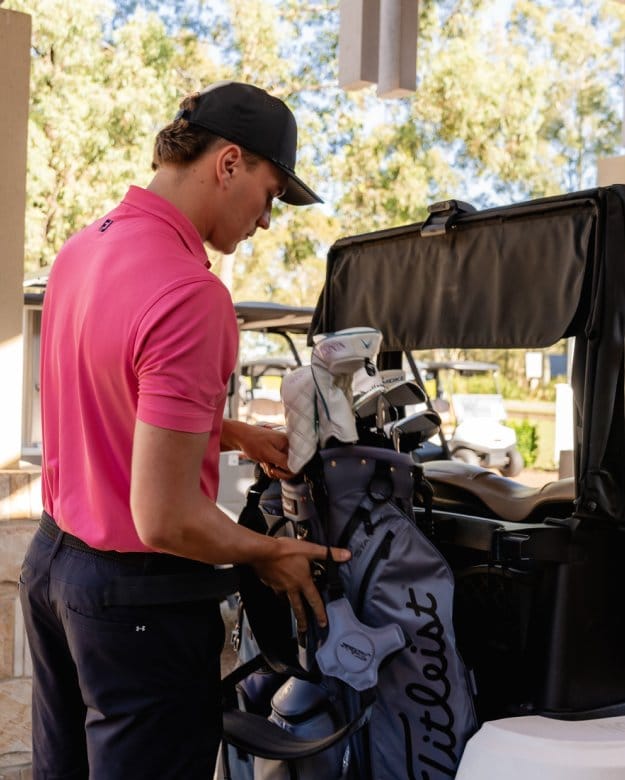 Golfer preparing equipment and clubs for a round of golf