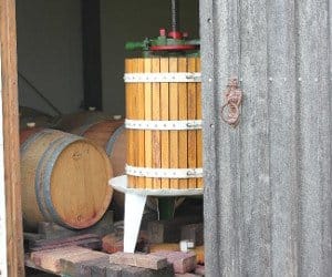 Wooden wine barrel with white metal bands in dim cellar space