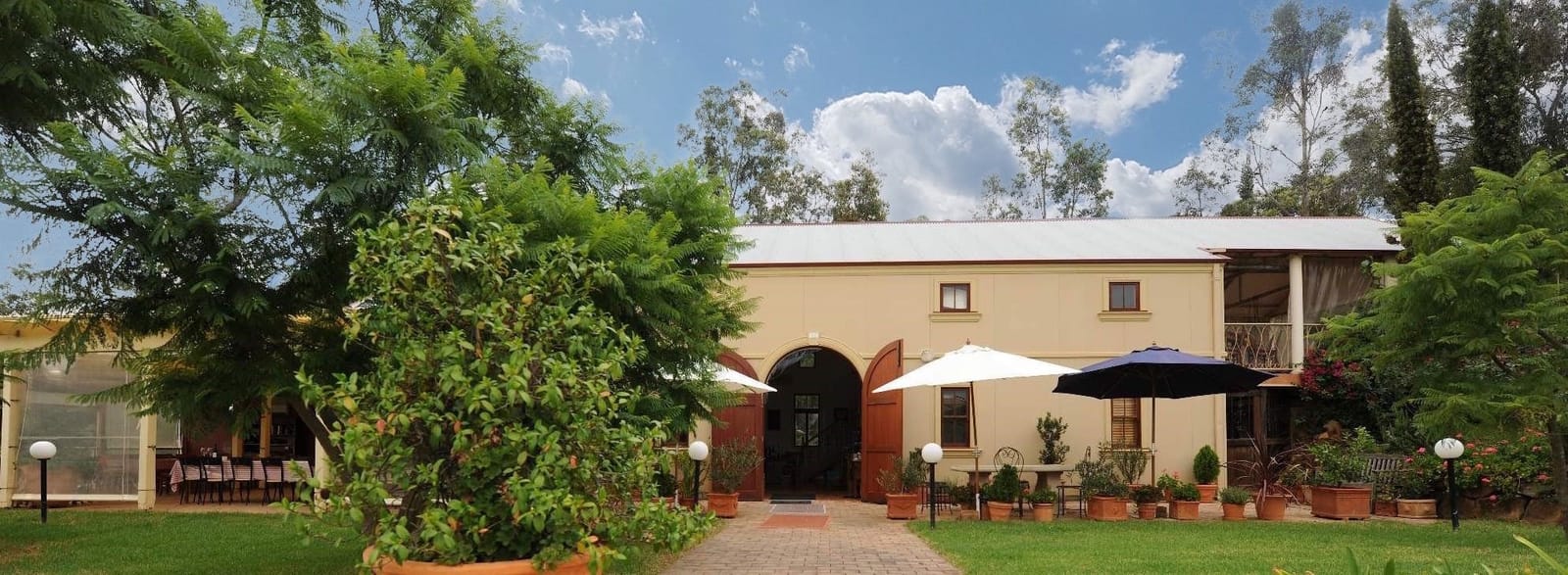 Cellar door building with umbrellas and potted plants along path at Tintilla Estate, Pokolbin, Hunter Valley